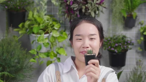 Front view of happy Asian young woman selling plants online Stock Footage 170659998