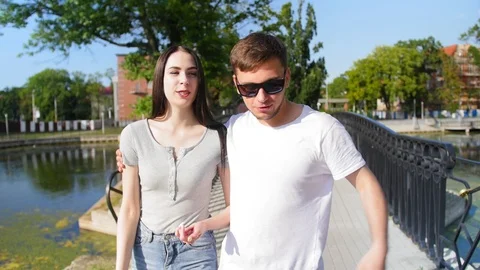 Front view of happy couple walking outdoor, smiling and talking together in park Stock Footage 116629465