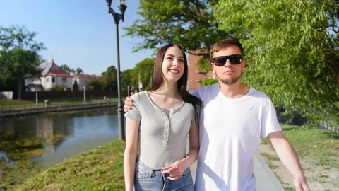 Front view of happy couple walking outdoor, smiling and talking together in park Stock Footage 116630048