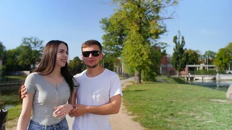 Front view of happy couple walking outdoor, smiling and talking together in park Stock Footage 116630130