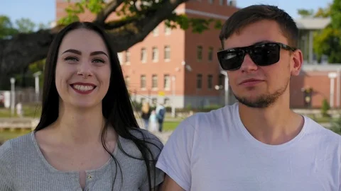 Front view of happy couple walking outdoor, smiling and talking together in park Stock Footage 116630627