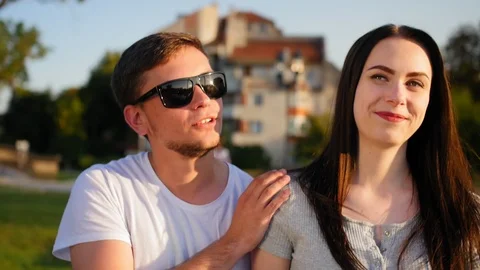 Front view of happy couple walking outdoor, smiling and talking together in park Stock Footage 116704099