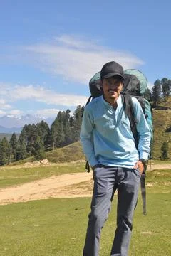 Front view of a happy young guy wearing cap with carrying parachute backpack Foto stock