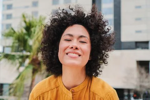 Front view of happy young hispanic woman smiling with curly hair Close up Stock Photos