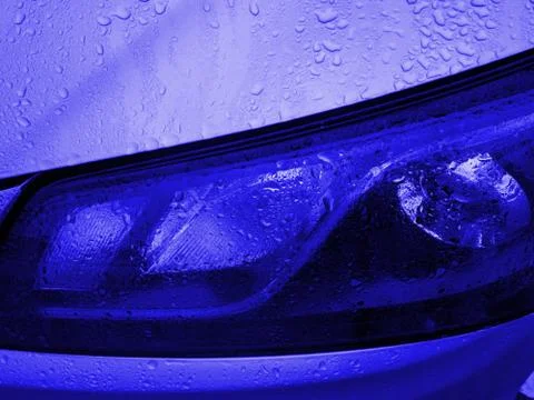 Front view of Headlight classic blue color covered with raindrops. Car exteri Stock Photos