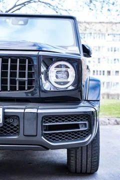 Front view of the headlight of a large black powerful prestigious car Stock Photos