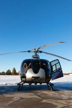 Front view of helicopter surrounded by snow with blue sky Stockfoto's