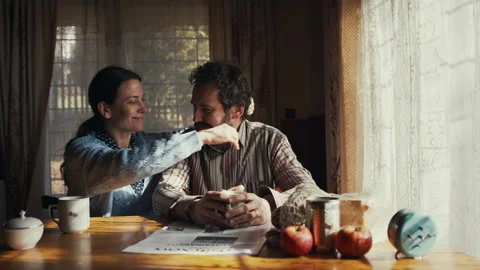Front view of humble poor couple with coffee indoors at home, hugging. Poverty Stock Footage 151336541