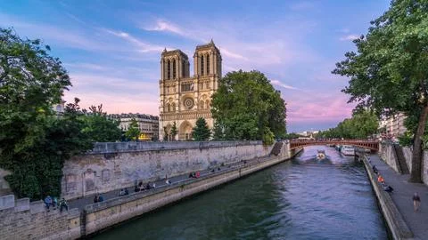 Front view of illuminated Notre Dame De Paris cathedral day to night transiti 写真素材