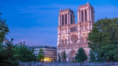 Front view of illuminated Notre Dame De Paris cathedral day to night transiti Stock Photos