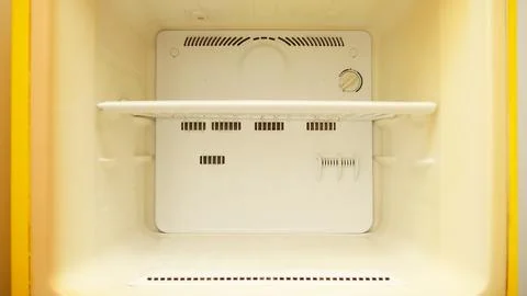 Front view of the interior of an empty, old, or vintage small refrigerator .. Stock Photos