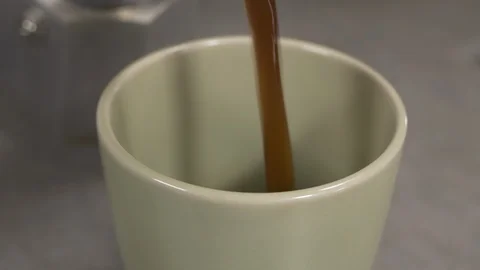 Front view- italian coffee maker pouring coffee in a green cup 4k. Stock Footage 96140993