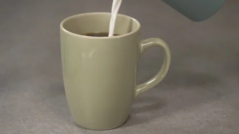 Front view- italian coffee maker pouring cream in a green coffee cup 4k. Stock Footage 96142641