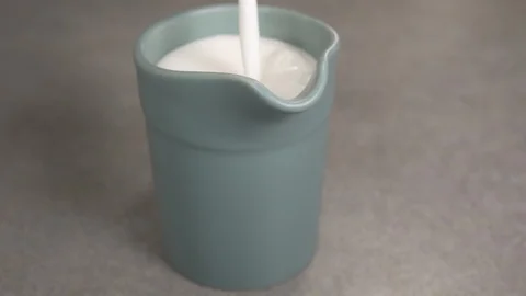 Front view-italian coffee maker pouring whipped dusty cream in a green jar 4k Video stock 96145281