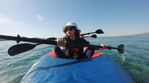 Front view of Kayakers paddle on inflatable kayak in clear sea waters Stock Footage 130112061