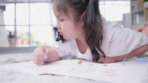 Front view of  kid lying on the floor doing painting by colour pencils Vídeo Stock 163775753