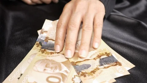 Front view -  lady dropping hundred dollar bills on a table 4k 動画素材 96010581