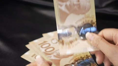 Front view-Lady placing hundred dollar bills on the table 4k. Stockbeeldmateriaal 96009242
