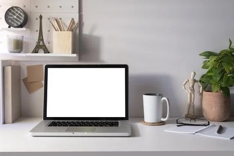 Front view laptop with blank screen, houseplant, coffee cup  and office sup.. Stock Photos