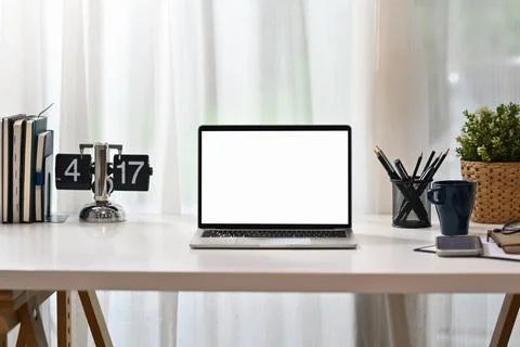 Front view laptop computer with blank display, books, coffee cup, stationery and Stock Photos