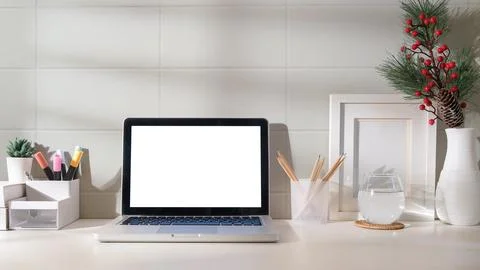 Front view laptop computer with empty screen on white table in bright room. Stock Photos