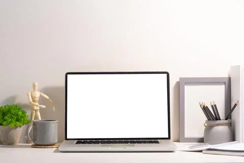 Front view of laptop computer with empty display, coffee cup and supplies o.. Stock Photos