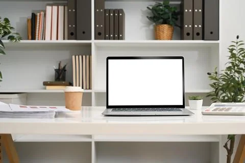 Front view laptop with empty display on a desk in front of a bookshelf Stock Photos