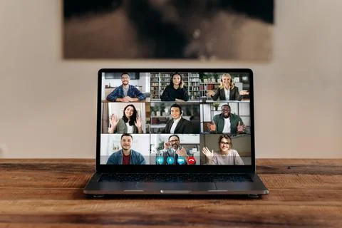 Front view at laptop screen standing on wood desk, with a group of multiracial Foto stock