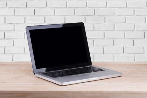Front view of the laptop is on the work table brick background Stock Photos