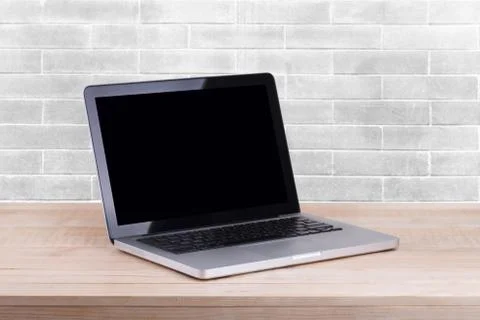 Front view of the laptop is on the work table white brick background Stock Photos