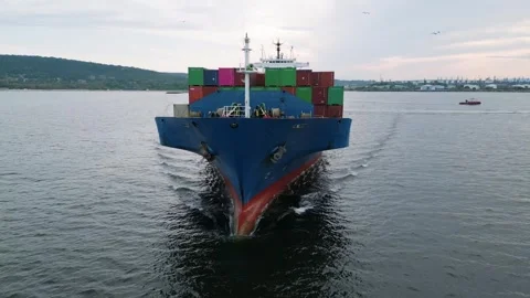 Front view of a large blue cargo ship carrying colorful containers sailing in Stock Footage 310300680