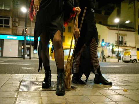 Front view of legs of two young women dressed as witches for Halloween on the Stock Photos