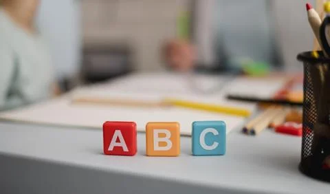 Front view letters cubes with defocused tutoring session back Resolution and Foto stock