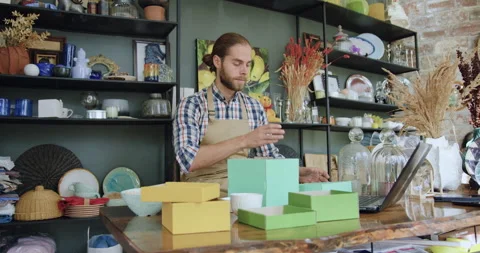 Front view of likable hardworking young bearded guy which packing wine glass Stock Footage 143971113
