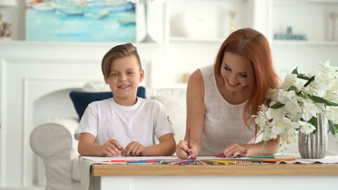 Front view - Little boy and his mother drawing and laugh at the table Stock Footage 115090189