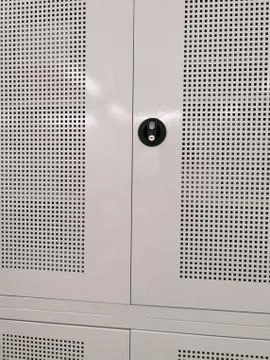 Front view of a locker with mesh grid and a black safety plate holder for a key. Stock Photos