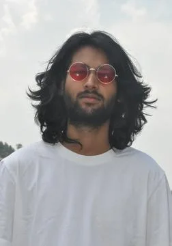 Front view of a long haired Indian young men wearing sunglasses Stock Photos
