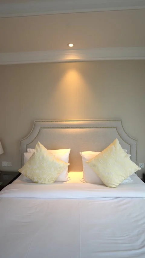 Front View of Luxury Hotel Bed with Yellow Pillows Stock Footage 334015964
