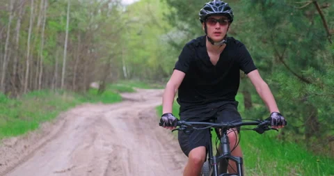 Front view to the man in a Bicycle helmet riding an mtb bike in the summer.Yo Stock Footage 130769200