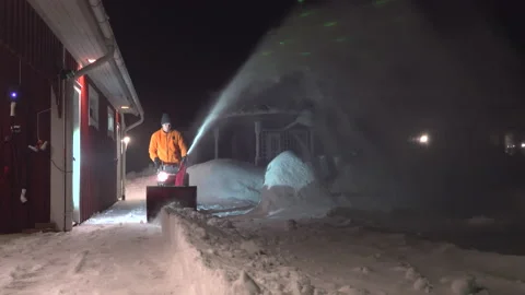Front view of man cleaning snow with snow blower machine at home parking Stock Footage 231370231