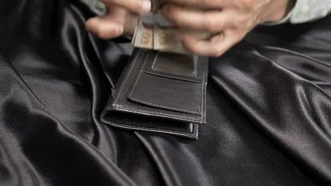 Front view - a man counting money and putting in a wallet 4k. Stock Footage 96001959