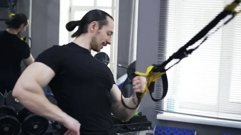 Front view of a man doing one arm push ups with gymnastic rings 库存影片 76848010