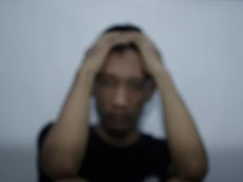Front view of a man holding his head showing stress motion blur Foto stock