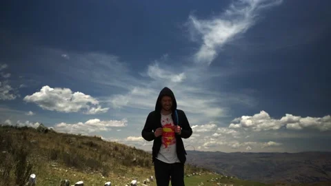 Front view of a man with hood and backpack walking on a trek in a mountain Stock Footage 164596656