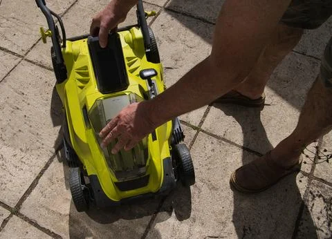 Front view of a man lifting flap inserting a charged lithium-ion battery in.. Stock Photos