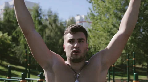Front view. Man with naked chest is pulling up outdoors. Stock Footage 68530446