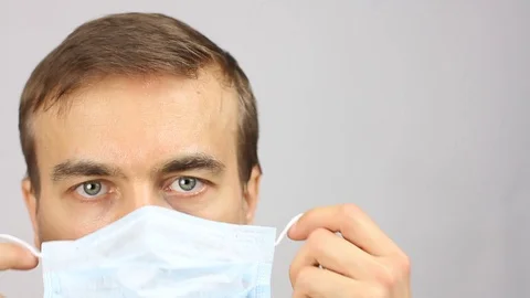 Front view man put on medical mask, prevention or virus protection or pollution Video stock 126597446