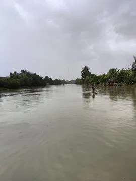 The front view of a man rowing a kayak across the river on a cloudy morning Stock Photos