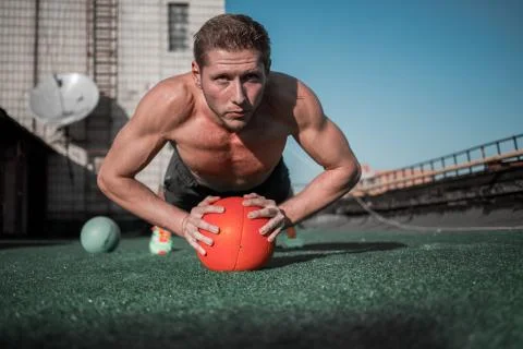 Front view of man standing in plank with hands on the ball. Stock Photos