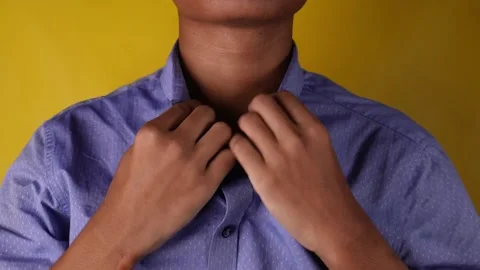 Front view of man tidy up his shirt collar isolated yellow background 库存影片 275886061